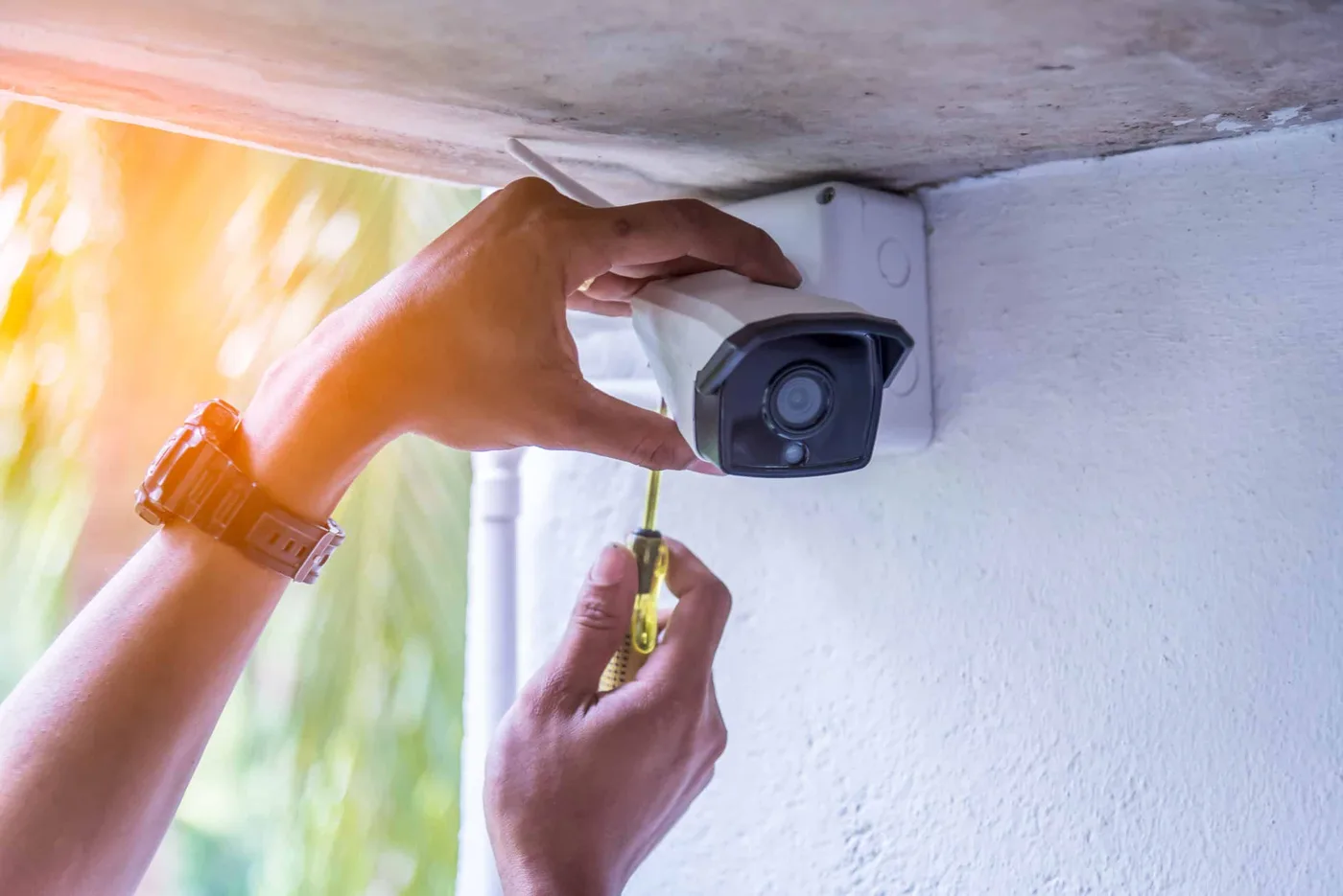 Technician mounting an outdoor security camera in Mississauga